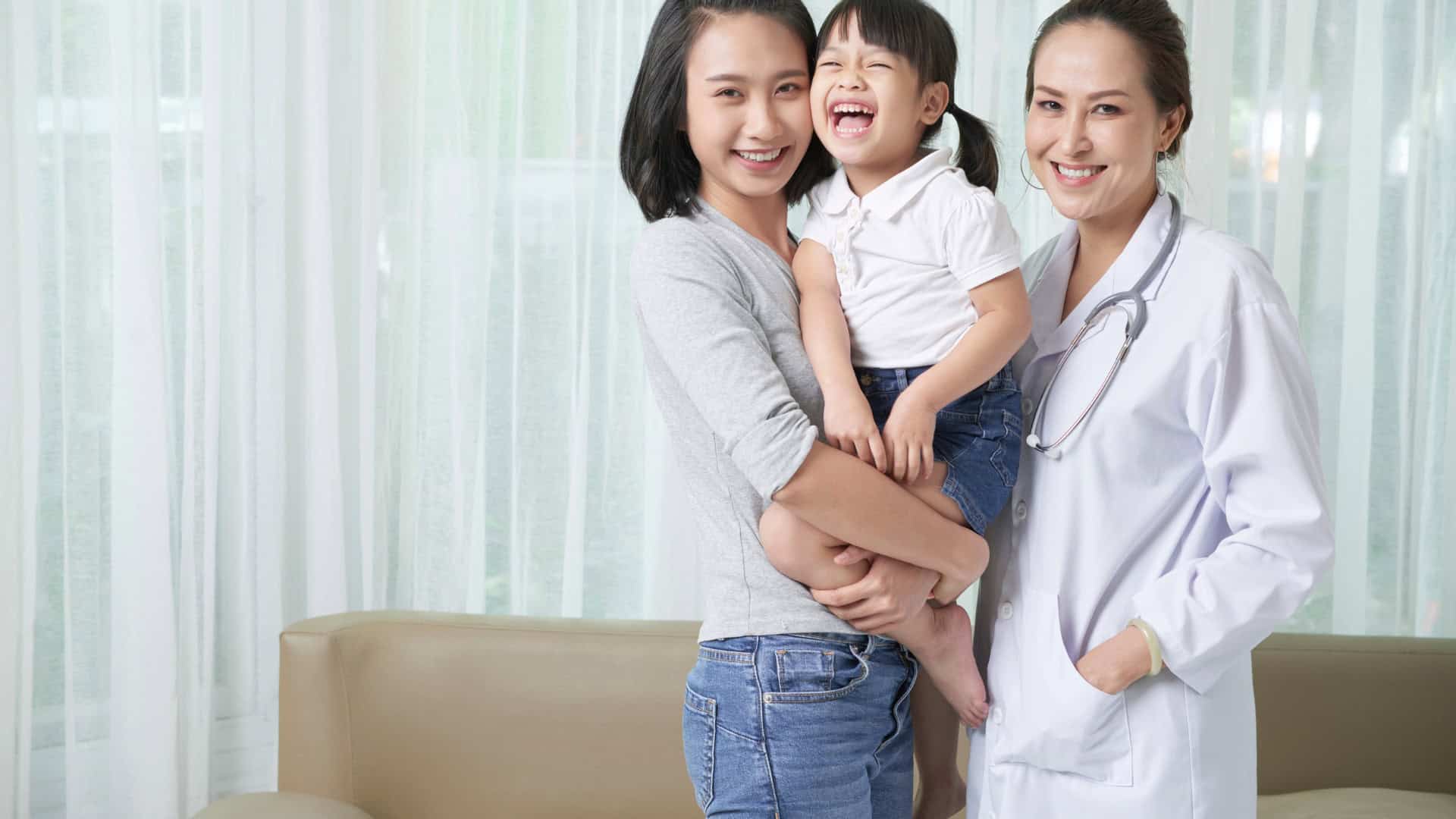 Image of a woman and her child being treated by a doctor in a home setting.